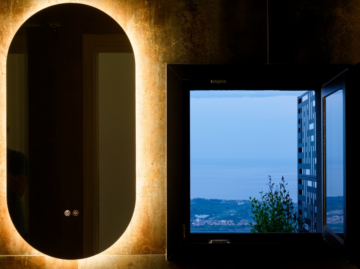 Illuminated mirror and sea view from the Suite Caricante bathroom
