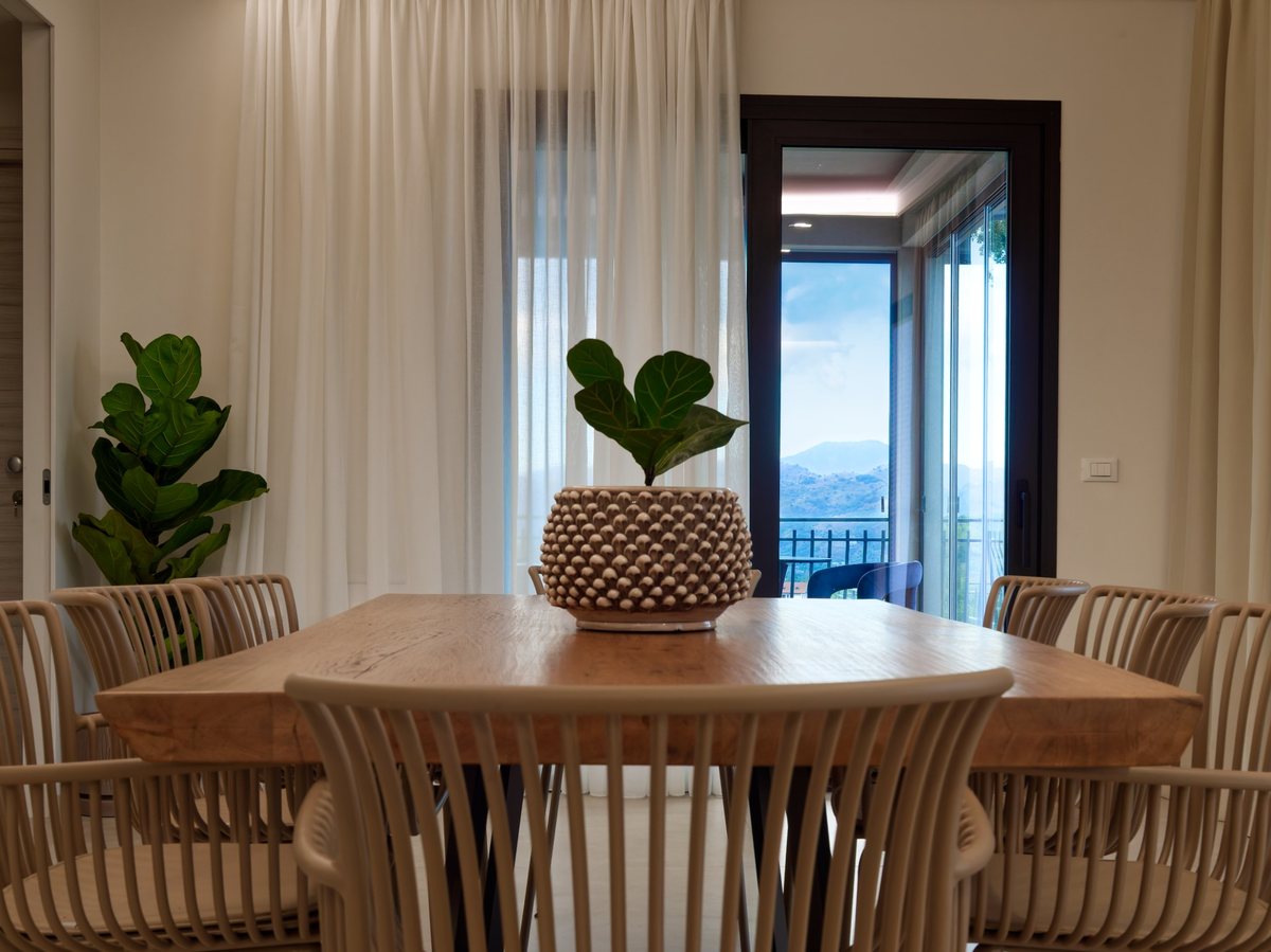 The villa’s dining table and interiors opening onto the view