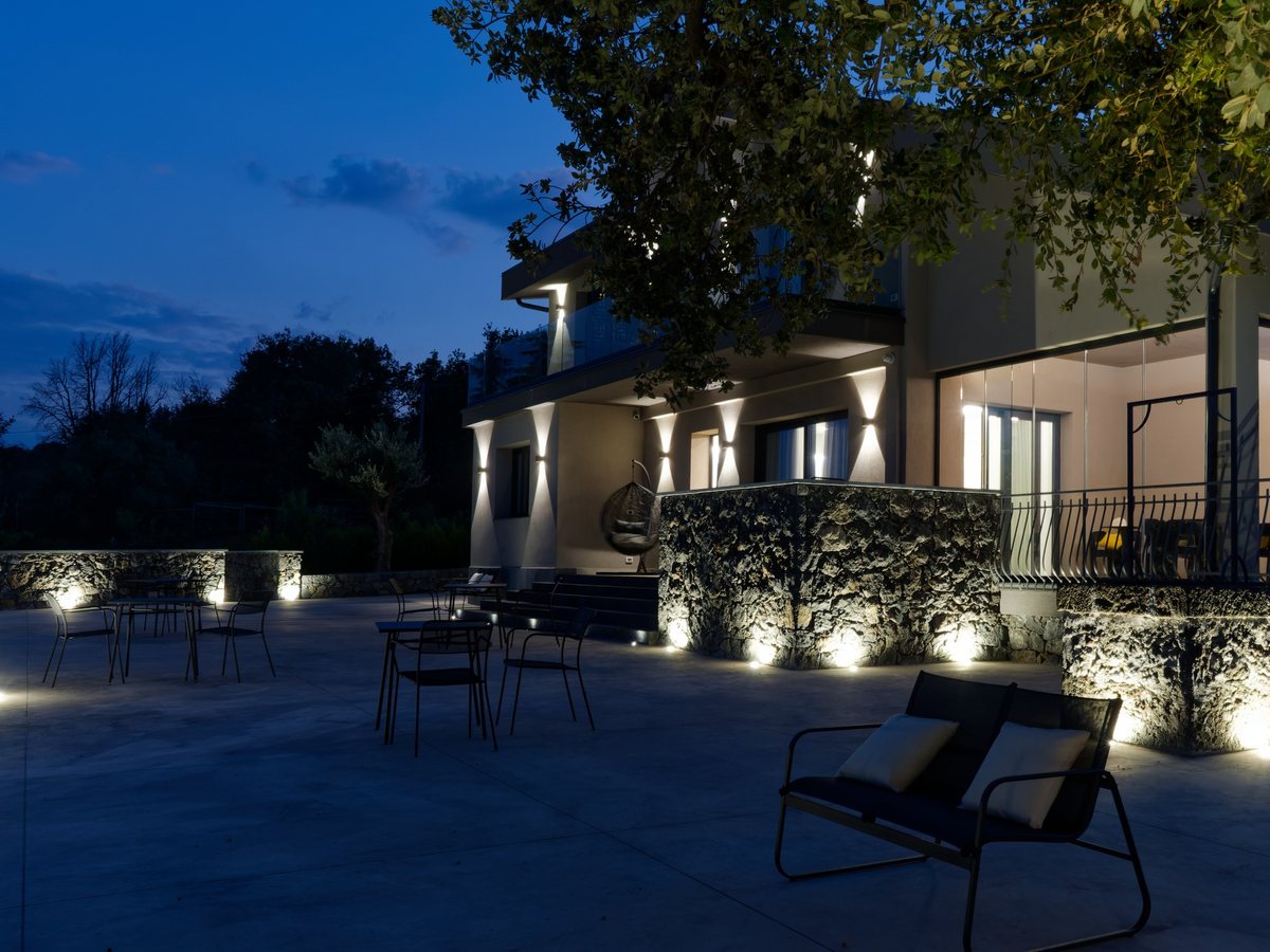The villa and terrace illuminated at blue hour